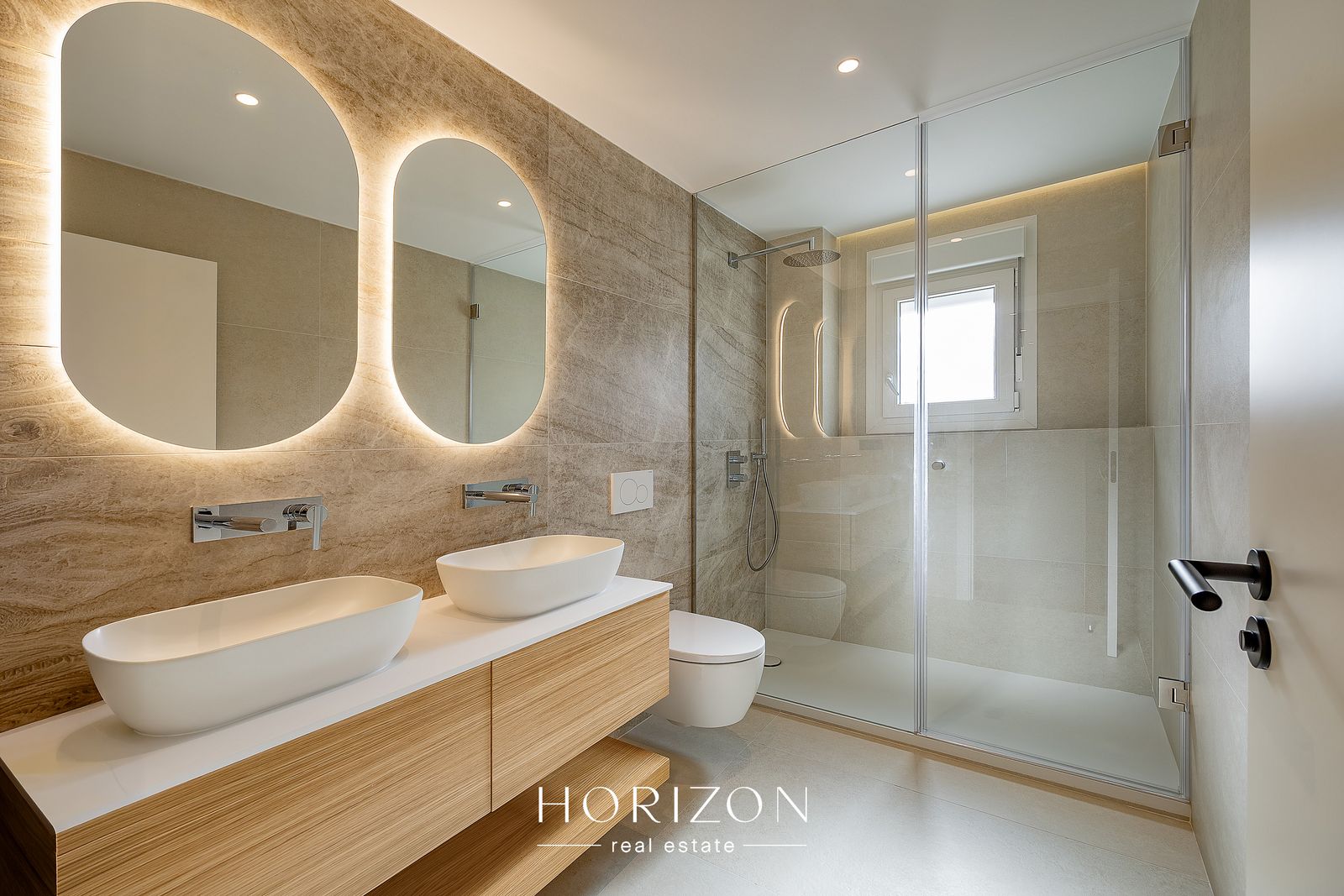 Main bathroom with double basin and backlit mirrors