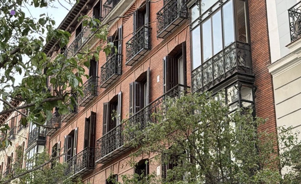 Brick facade of the Orellana building with wrought-iron balconies