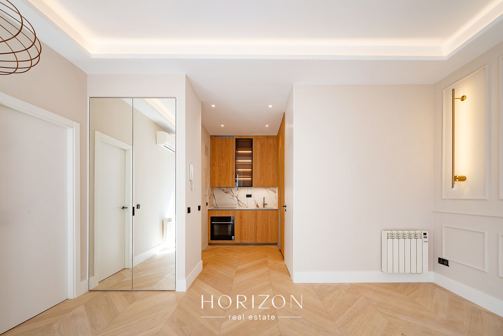 Open entrance with mirrored wardrobe and oak kitchen after renovation