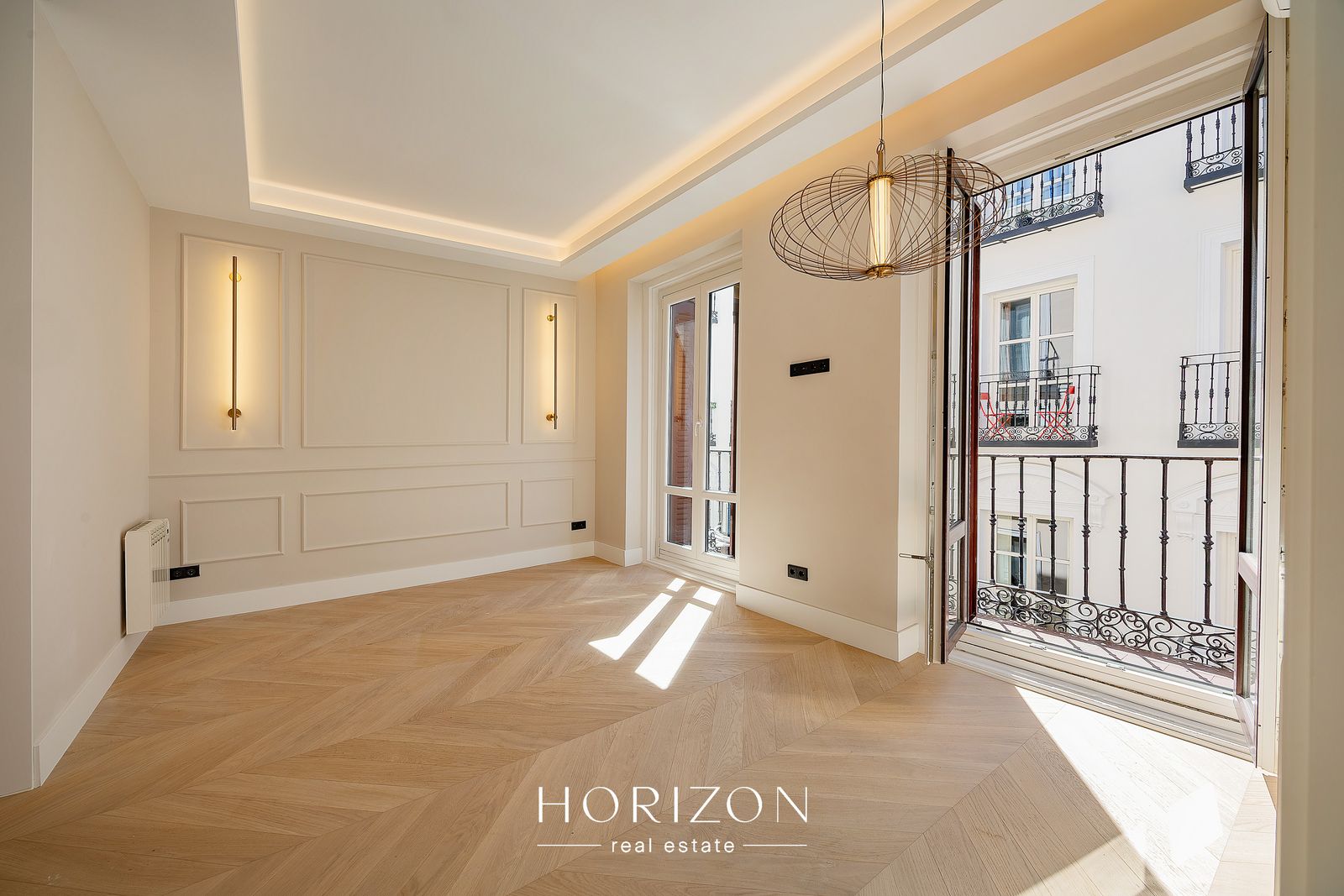 Living room with balcony doors and wire pendant