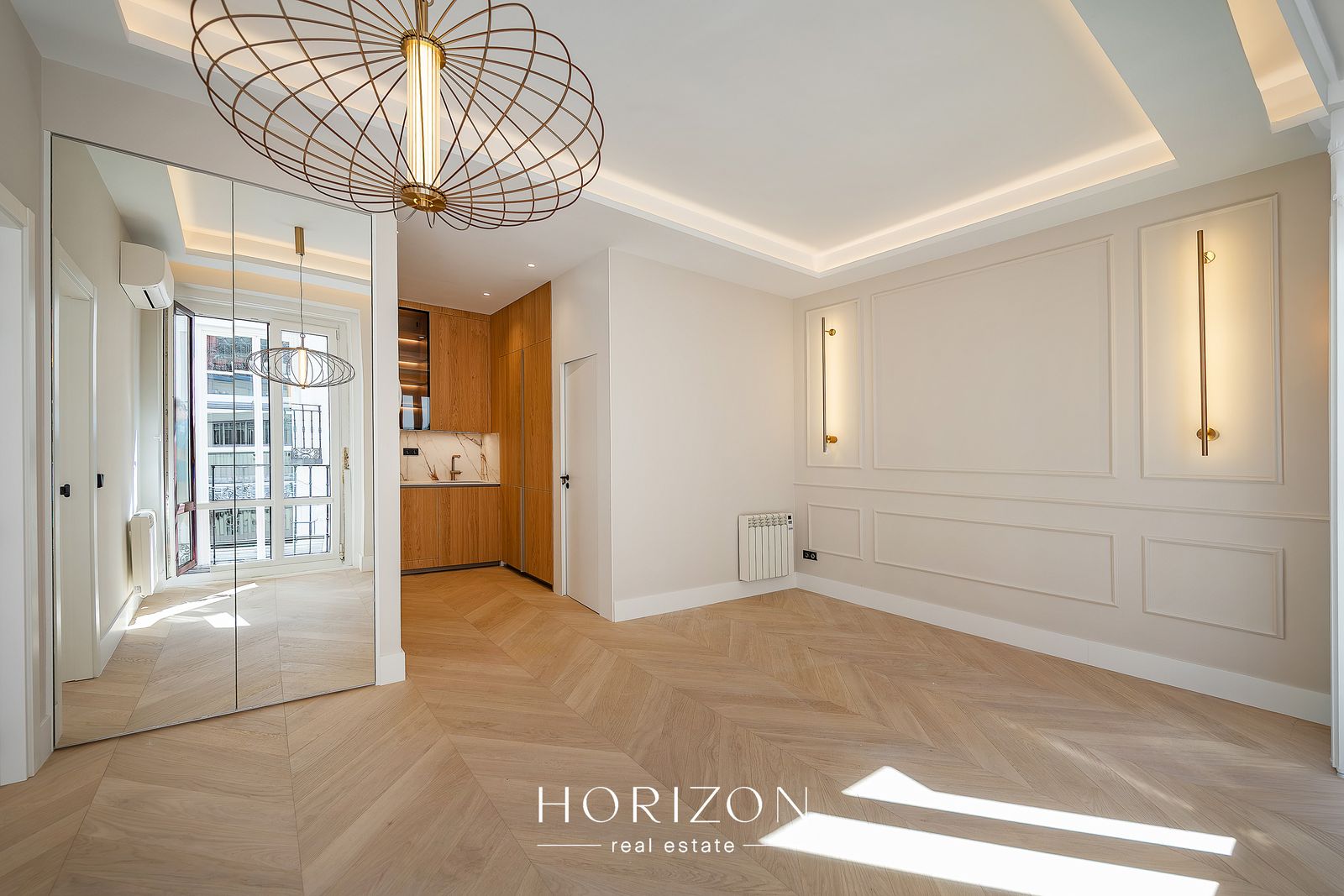 Living room with mirrored wardrobe and kitchen beyond